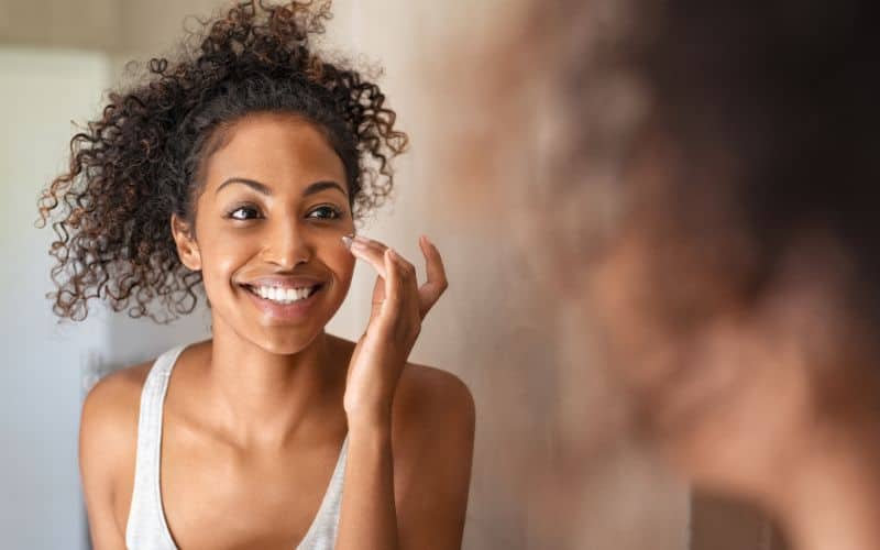 collagen-powder-young-black-woman-applying-skin-cream-min