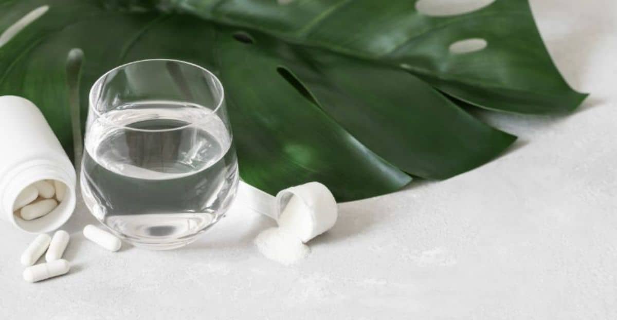 collagen-tablets-and-water-on-a-gray-background-with-a-monstera-leaf-closeup-additional-protein-intake-natural-healthy-min